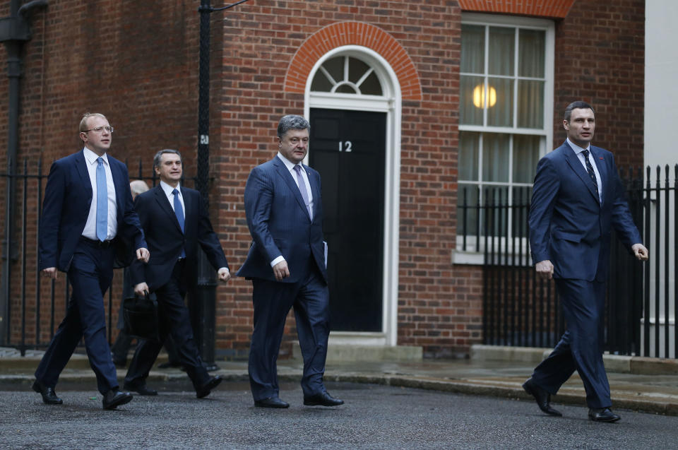 Ukraine's MPs Vitali Klitschko, leader of the UDAR (Ukrainian Democratic Alliance for Reform) party, right, Petro Poroshenko, Independent, centre, and Andriy Shevchenko, Fatherland party, left, arrive at 10 Downing Street in London for a meeting with British Prime Minister David Cameron and Foreign Secretary William Hague, Wednesday, March 26, 2014. (AP Photo/Sang Tan)