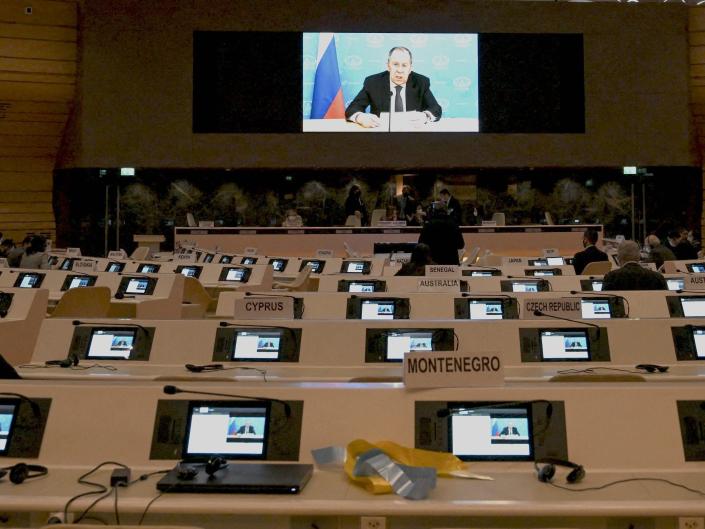 The UN Security Council meeting room appears almost empty while a Russian representative is speaking remotely on a monitor.