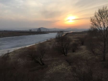 The frozen Tumen river separating North Korea (L) from China is seen in this photo taken from the Chinese border city of Hunchun, China, March 18, 2015. REUTERS/Staff