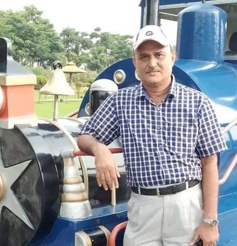 Handout photograph shows Samir Kumar Mitra posing for a photograph next to a train engine model in an unknown location