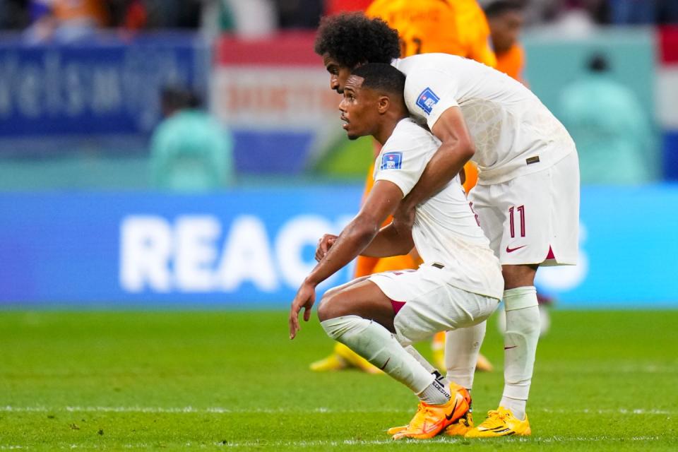 Qatar's Akram Afif embracers a teammate at the end of their 0-2 lost against Netherlands during a World Cup group A football match at the Al Bayt Stadium in Al Khor, Qatar, Tuesday, Nov. 29, 2022. (AP Photo/Petr David Josek)