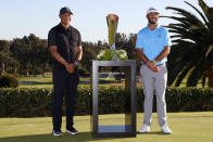 Max Homa, right, poses with his trophy next to Tiger Woods on the practice green after winning the Genesis Invitational golf tournament at Riviera Country Club, Sunday, Feb. 21, 2021, in the Pacific Palisades area of Los Angeles. (AP Photo/Ryan Kang)