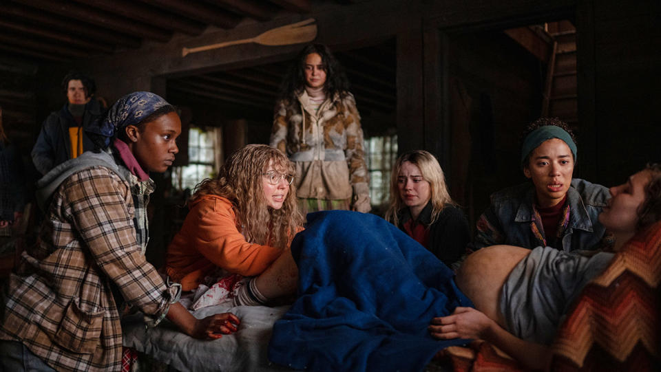 (L-R): Kevin Alves as Teen Travis, Nia Sondaya as Teen Akilah, Samantha Hanratty as Teen Misty, Courtney Eaton as Teen Lottie, Sophie Thatcher as Teen Natalie, Jasmin Savoy Brown as Teen Taissa and Sophie Nélisse as Teen Shauna in YELLOWJACKETS, "Qui".