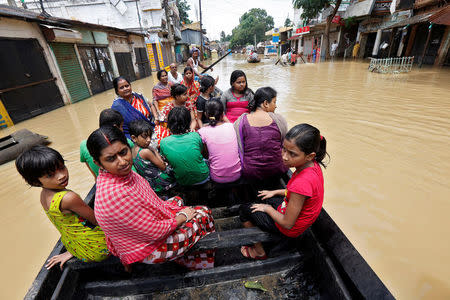People use a boat as they try to move to safer places along a flooded street in West Midnapore district, in West Bengal, July 27, 2017. REUTERS/Rupak De Chowdhuri