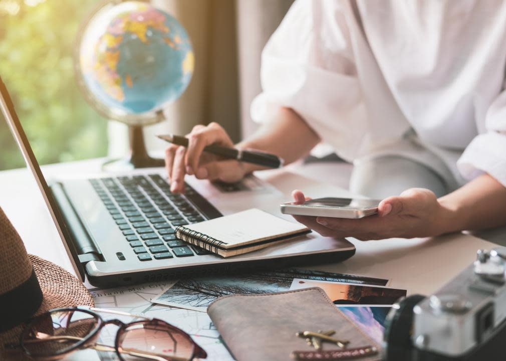 Young traveler planning vacation and searching information on laptop.