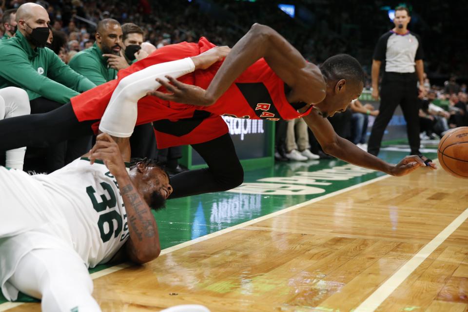 Boston Celtics' Marcus Smart (36) and Toronto Raptors' Chris Boucher battle for the ball during the second half of an NBA basketball game, Friday, Oct. 22, 2021, in Boston. (AP Photo/Michael Dwyer)