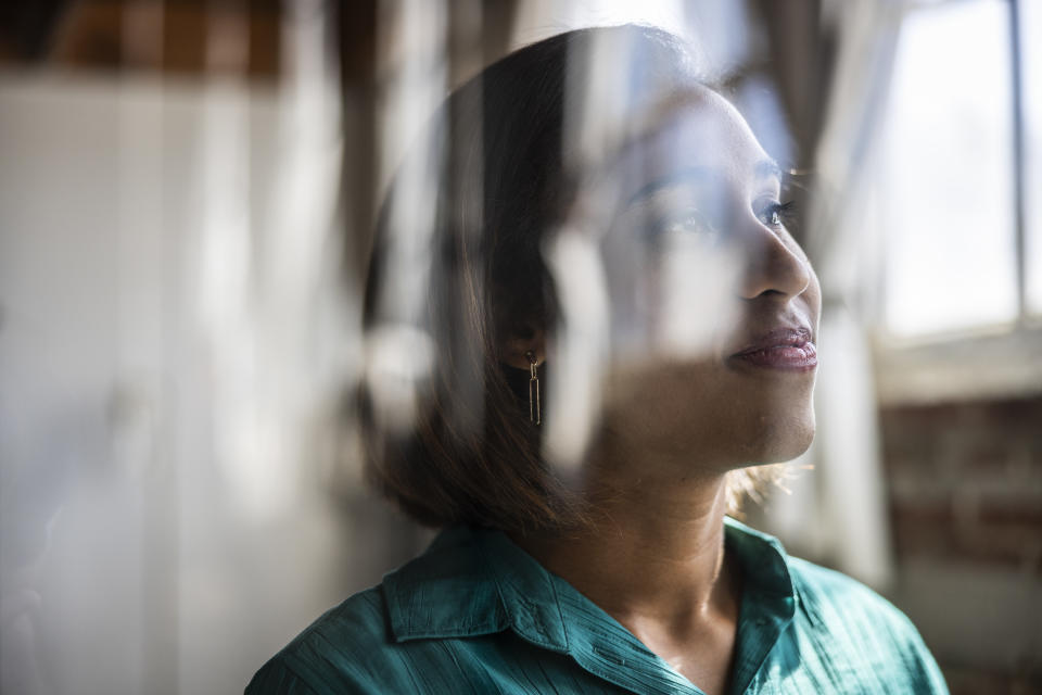 Portrait of female businesswoman reflecting in glass window