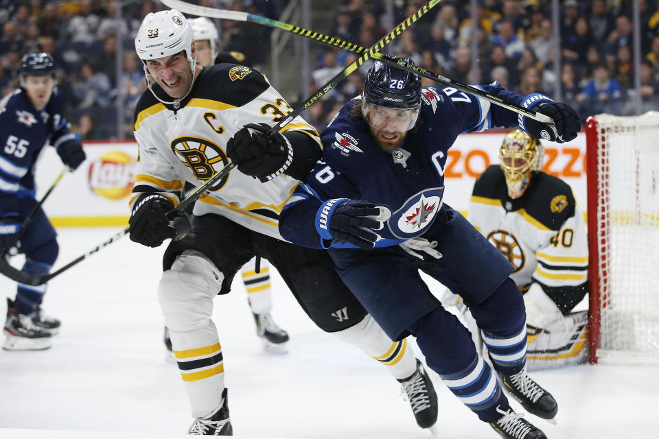 Winnipeg Jets' Blake Wheeler (26) and Boston Bruins' Zdeno Chara (33) chase the puck as goaltender Tuukka Rask (40) watches during the second period of an NHL hockey game Friday, Jan. 31, 2020, in Winnipeg, Manitoba. (John Woods/The Canadian Press via AP)