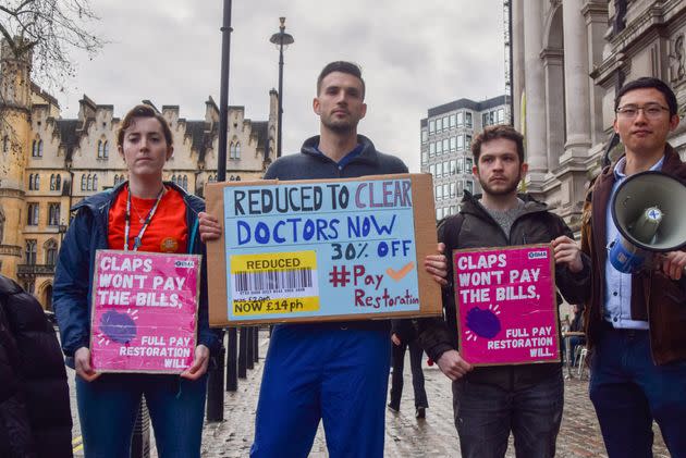 Junior Doctors Committee (JDC) members hold placards demanding full pay restoration during a demonstration at Central Hall Westminster last year.