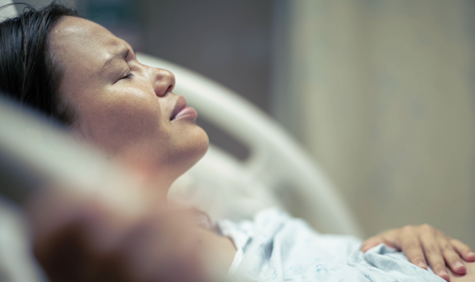 A pregnant woman in pain lying in bed