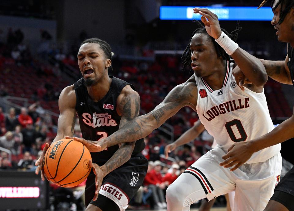 Cardinals guard Mike James scrambles for the ball against New Mexico State guard Jordan Rawls during overtime.