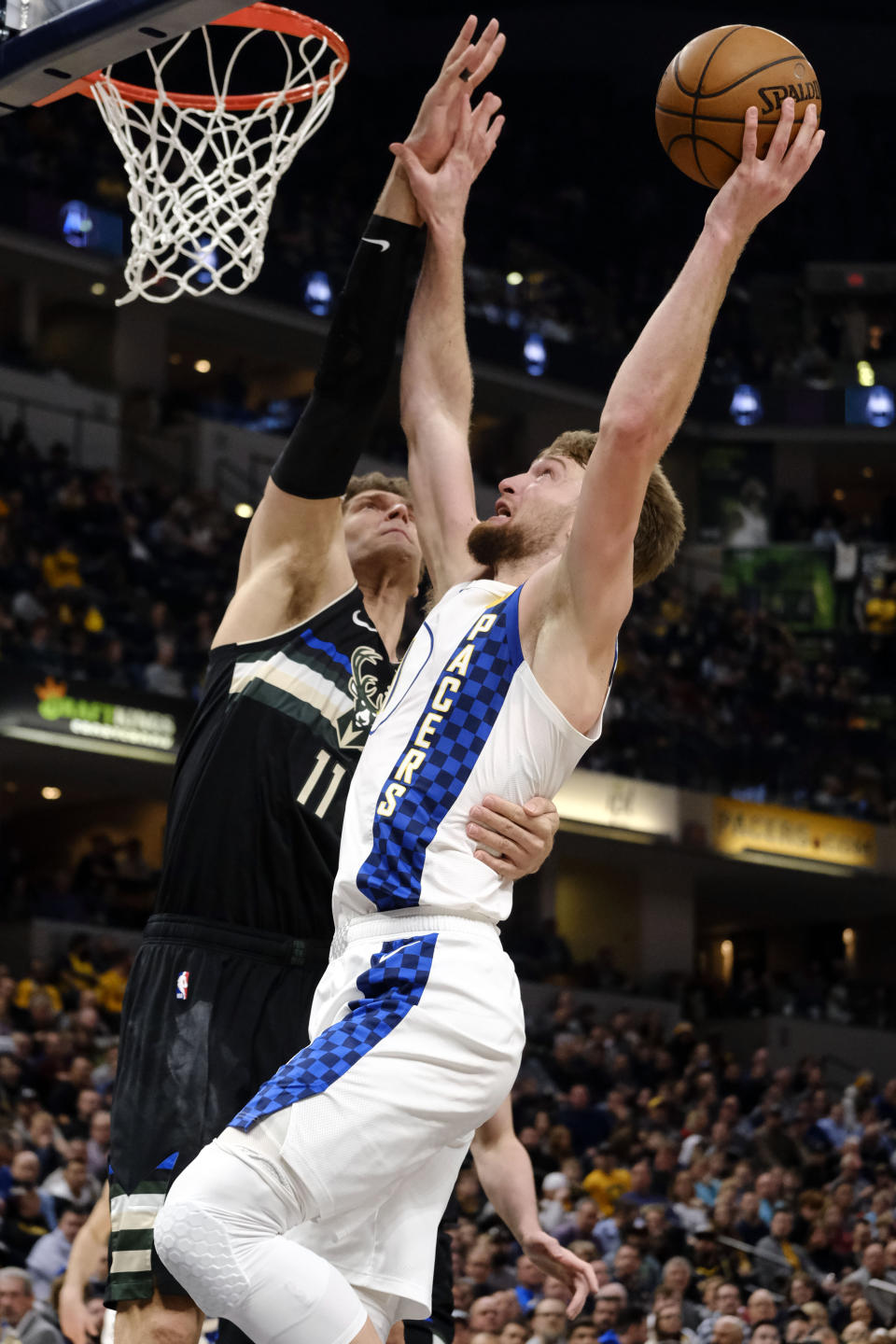 Indiana Pacers forward Domantas Sabonis, right, is fouled by Milwaukee Bucks center Brook Lopez during the first half of an NBA basketball game in Indianapolis, Wednesday, Feb. 12, 2020. (AP Photo/AJ Mast)