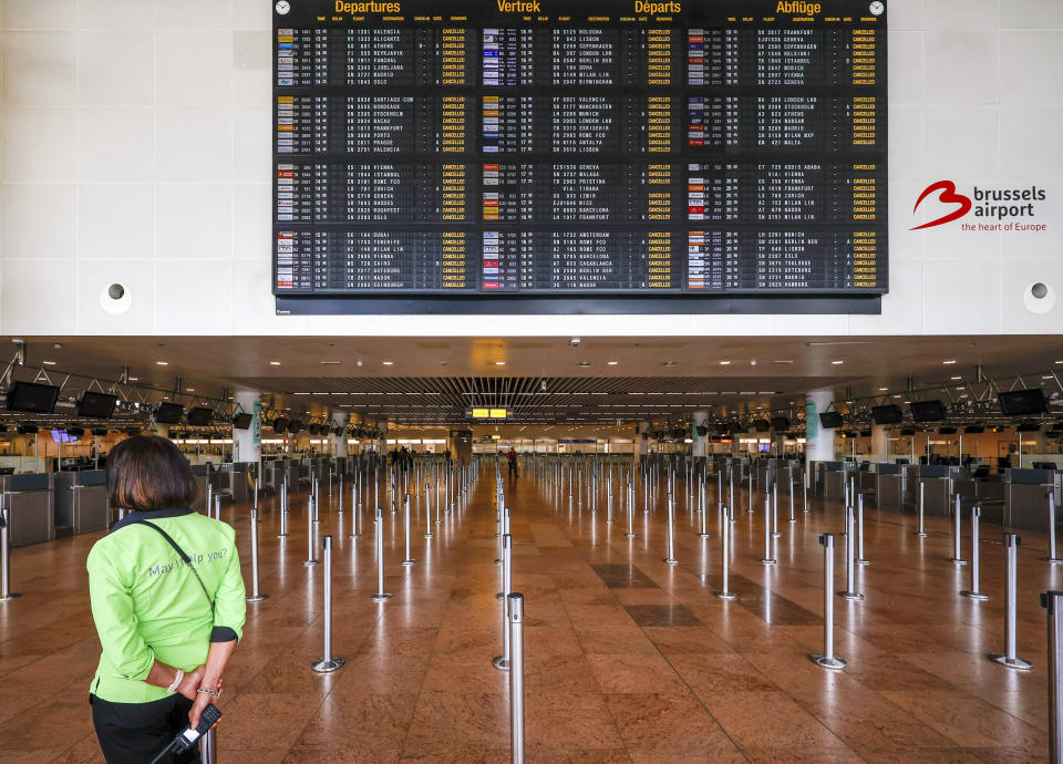 FILE - An employee stands under a departures board with cancelled flights in the departures hall at Brussels international airport during a general strike in Brussels, Monday, June 20, 2022. After two years of pandemic restrictions, travel demand is back with a vengeance but airlines and airports that slashed jobs during the depths of the COVID-19 crisis are struggling to keep up. With the busy summer tourism season underway in Europe, passengers are encountering chaotic scenes at airports, including lengthy delays, canceled flights and headaches over lost luggage. (AP Photo/Olivier Matthys, File)