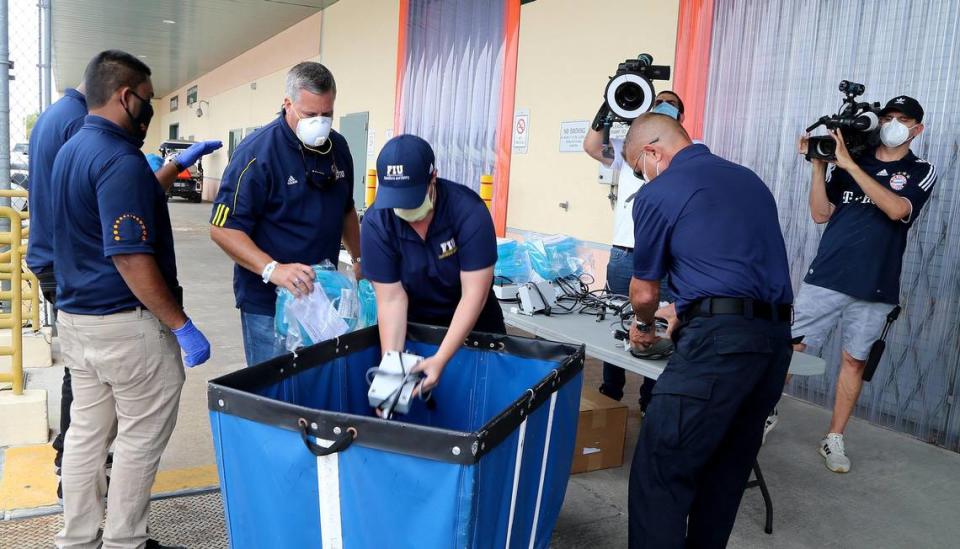 FIU staff members Javier Marquez (second from left), vice president and chief of staff, and Bridget Pelaez (center), FIU assistant director, emergency, load a set of ventilators that Florida International University is lending to the state to treat patients affected by the COVID-19 outbreak, on Wednesday, April 8, 2020.