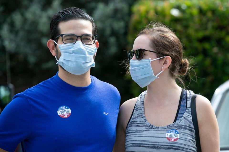 Emilio Lopez and Rebecca Longtemps wear I Voted stickers along with protective masks against the Coronavirus COVID-19 after voting in the Florida primary at the Voting Place at Coral Gables Library in Coral Gables on Tuesday, March 17, 2020.