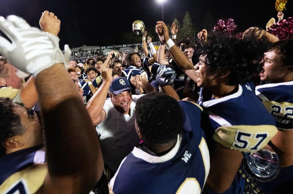Central Catholic players and head coach Roger Canepa, middle, celebrate the Valley Oak League victory over Manteca at Central Catholic High School in Modesto, Calif., Friday, Oct. 20, 2023.