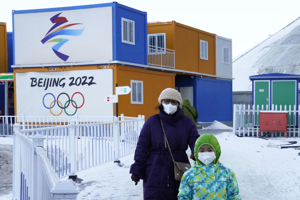 Visitors pass by the logos for the Beijing 2022 Winter Olympics in Zhangjiakou in northwestern China's Hebei province on Dec. 16, 2020. Calls for a boycott of the 2022 Beijing Winter Olympics on human rights grounds are “doomed to failure,” a Chinese government spokesperson said Wednesday, March 3, 2021, as lawmakers and political advisers began converging on China's capital for the biggest annual gathering of the political calendar. (AP Photo/Ng Han Guan)