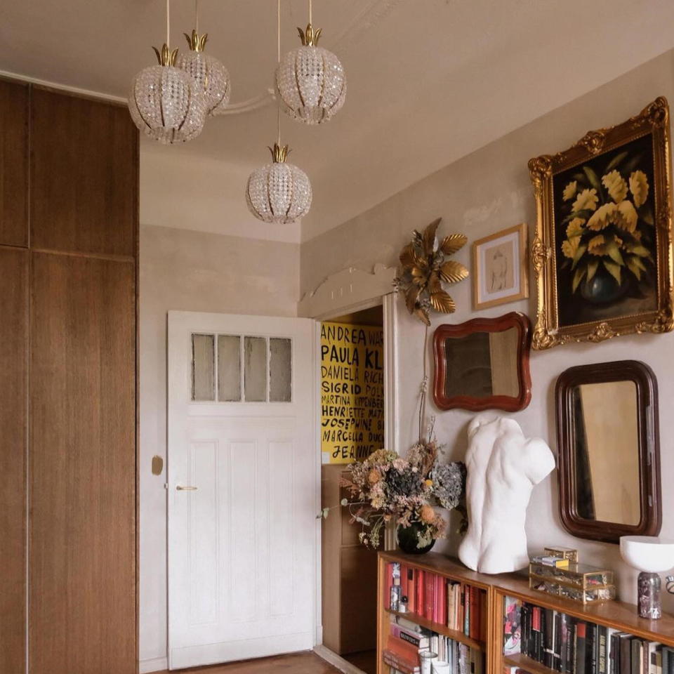 room with book shelves and gallery wall with art and mirrors