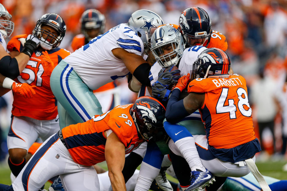 <p>Running back Ezekiel Elliott #21 of the Dallas Cowboys is tackled by Adam Gotsis #99 and outside linebacker Shaquil Barrett #48 of the Denver Broncos int he first quarter of a game at Sports Authority Field at Mile High on September 17, 2017 in Denver, Colorado. (Photo by Justin Edmonds/Getty Images) </p>