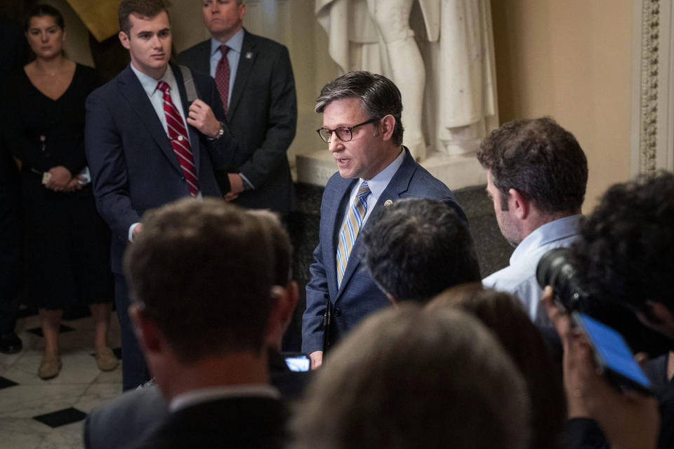 Reporters and staffers circle Rep. Mike Johnson as he speaks (Jacquelyn Martin / AP)