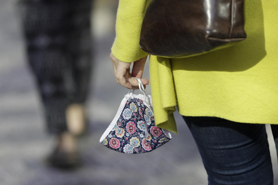 A woman carries a face mask in Prague, Czech Republic, Monday, Sept. 21, 2020. The country coped well with the first wave of the coronavirus infections in the spring but has been facing a record surge of the new confirmed cases last week. (AP Photo/Petr David Josek)