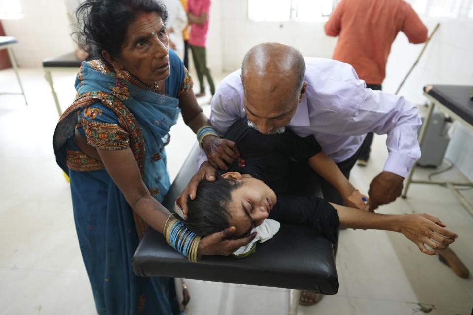 FILE - A father tries to calm his daughter suffering from heat related ailment as she is brought to the government district hospital in Ballia, Uttar Pradesh state, India, June 19, 2023. The latest calculations from several science agencies Friday, Jan. 12, 2024, all say that global average temperatures for 2023 shattered existing heat records. (AP Photo/Rajesh Kumar Singh, File)