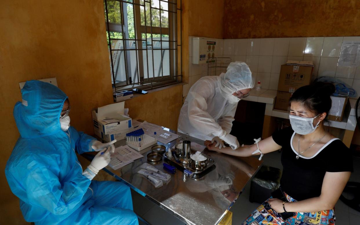 Vietnamese health workers check for the coronavirus - Kham/Reuters 