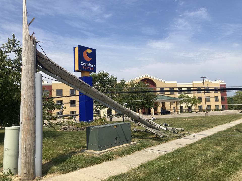 A utility pole lies at the entrance to a hotel on Friday, June 30, 2023, snapped off in derecho winds that hit Springfield, Ill., a day earlier along with a string of others on an east-side commercial strip just west of Interstate 55. (AP Photo/John O'Connor)