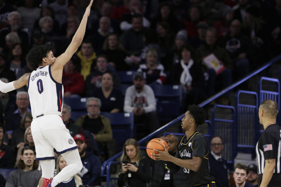 Kent State forward Miryne Thomas, right, prepares to shoot while defended by Gonzaga guard Julian Strawther during the first half of an NCAA college basketball game, Monday, Dec. 5, 2022, in Spokane, Wash. (AP Photo/Young Kwak)