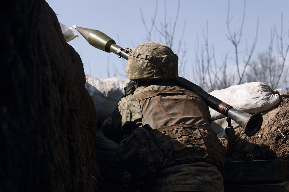 A Ukrainian soldier of the 28th brigade fires a grenade launcher on the frontline during a battle with Russian troops near Bakhmut, Donetsk region, Ukraine, Friday, March 24, 2023. (AP Photo/Libkos)