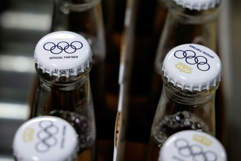 Le logo des Jeux olympiques sur des capsules de bouteilles de bière sans alcool Corona Cero, sur une ligne de production à la brasserie Anheuser-Busch InBev (AB InBEV), le 23 avril 2024 à Louvain, en Belgique (Kenzo TRIBOUILLARD)