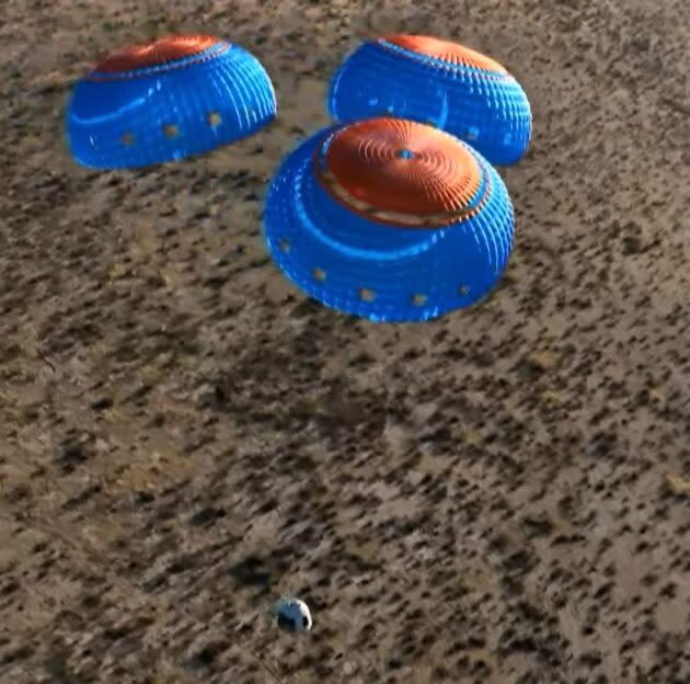 The New Shepard crew capsule floats down on the end of its parachutes. (Blue Origin via YouTube)