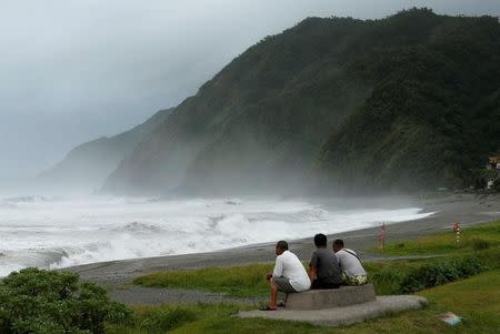 Men watch waves crash at the coast as Typhoon Nepartak approaches in Yilan, Taiwan July 7, 2016. REUTERS/Tyrone Siu