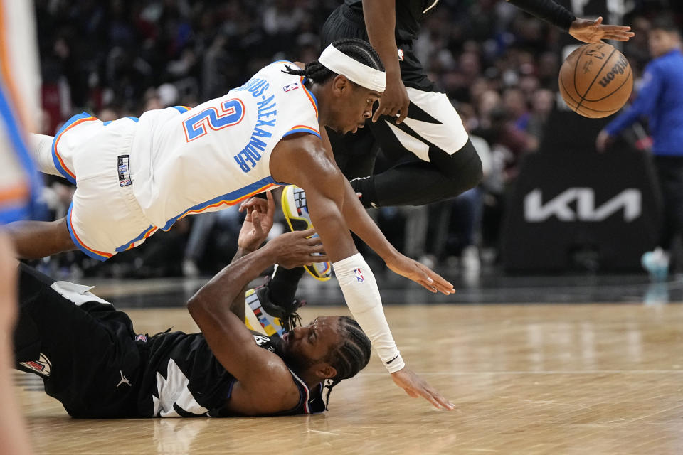 Oklahoma City Thunder guard Shai Gilgeous-Alexander, top, and LA Clippers forward Kawhi Leonard fall as the ball gets loose during the second half of an NBA basketball game Thursday, March 23, 2023, in Los Angeles. (AP Photo/Mark J. Terrill)