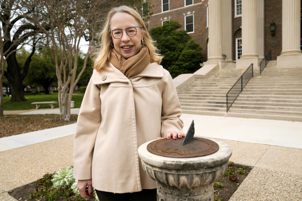 Alexis McCrossen poses for a photo by a sun dial on the campus of Southern Methodist University in Dallas, Wednesday, Feb. 28, 2024. McCrossen, a history professor at SMU, has written books on marking time. (AP Photo/Tony Gutierrez)