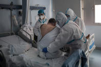 Patient Laurentiu Vania Hancu is lifted by a medical team during a physiotherapy session at the COVID-19 ward in the Severo Ochoa Hospital in Leganes on the outskirts of Madrid, Spain, Wednesday, Feb. 17, 2021. (AP Photo/Bernat Armangue)