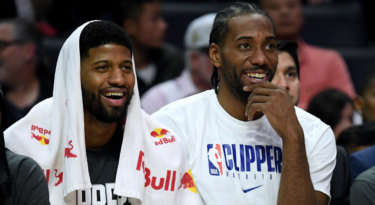 LOS ANGELES, CALIFORNIA - DECEMBER 17:  Paul George #13 and Kawhi Leonard #2 of the LA Clippers laugh on the bench during a 120-99 win over the Phoenix Suns at Staples Center on December 17, 2019 in Los Angeles, California. (Photo by Harry How/Getty Images)