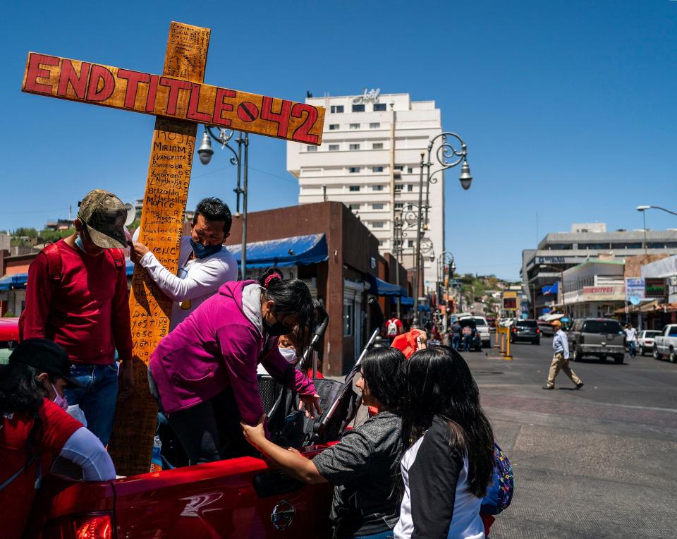Protesters lift a cross with the words "End Title 42" writing on it during a vigil near the DeConcini port of entry for the continuation of Title 42 on Monday, May 23, 2022, in Nogales, Mexico. A federal judge in Louisiana ruled that Title 42, a Trump administration era public health order, must stay in place, making it difficult for migrants in Mexico to seek asylum in the U.S.