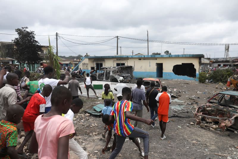 People arrive a day after to the yard of a police station that was set on fire by protesters during a demonstration against the decision of Ivory Coast President Alassane Ouattara to run for a third term in the next presidential election, in Bonoua