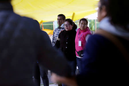 People who are living in a shelter because their homes were damaged in an earthquake, are united in a prayer after a tremor was felt in Mexico City, Mexico September 23, 2017. REUTERS/Daniel Becerril