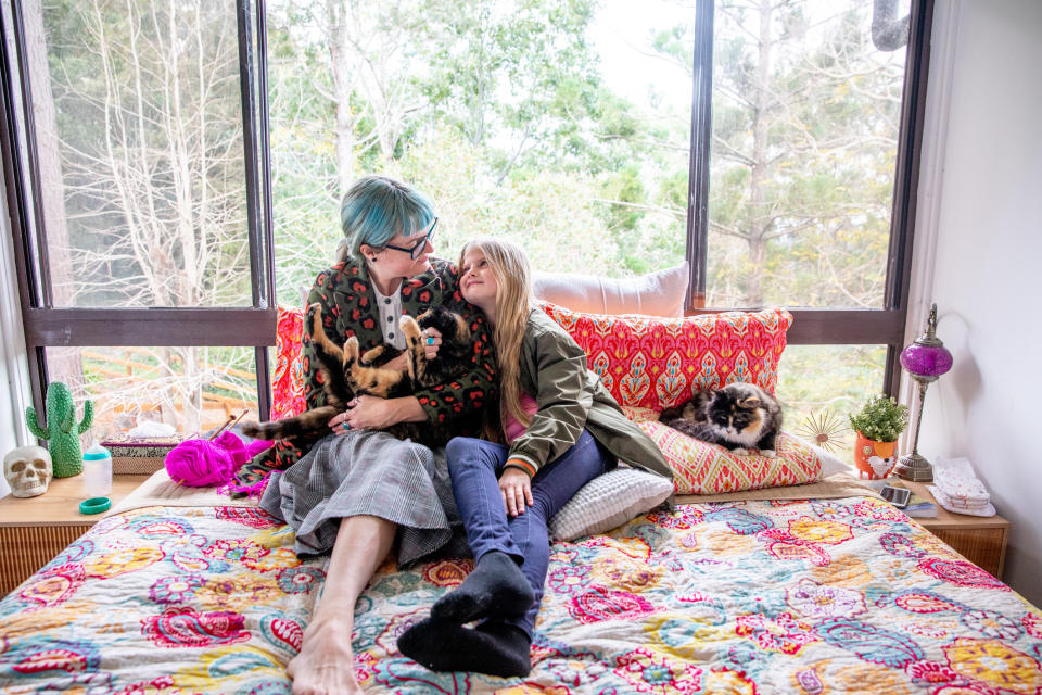 Mom and daughter sitting on a bed together talking