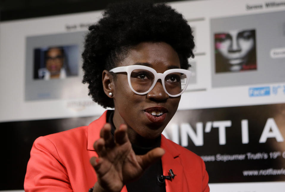 In this Wednesday, Feb. 13, 2019, photo, Massachusetts Institute of Technology facial recognition researcher Joy Buolamwini takes questions from reporters at the school, in Cambridge, Mass. Buolamwini's research has uncovered racial and gender bias in facial analysis tools sold by companies such as Amazon that have a hard time recognizing certain faces, especially darker-skinned women. (AP Photo/Steven Senne)