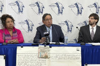 Arlan Melendez, chairman of the Reno-Sparks Indian Colony, center, speaks as tribal historic preservation officer Michon Ebren, left, and attorney Will Falk listen during a news conference, Tuesday, Dec. 5, 2023 in Reno, Nevada. Melendez announced the tribe is abandoning its 3-year lawsuit aimed at blocking a lithium mine currently under construction at Thacker Pass in northwest Nevada. Tribal leaders say the U.S. Interior Department refuses to accept their arguments that the mine's on a sacred site where more than two dozen Paiute and Shoshone ancestors were massacred in 1865. (AP Photo/Scott Sonner)