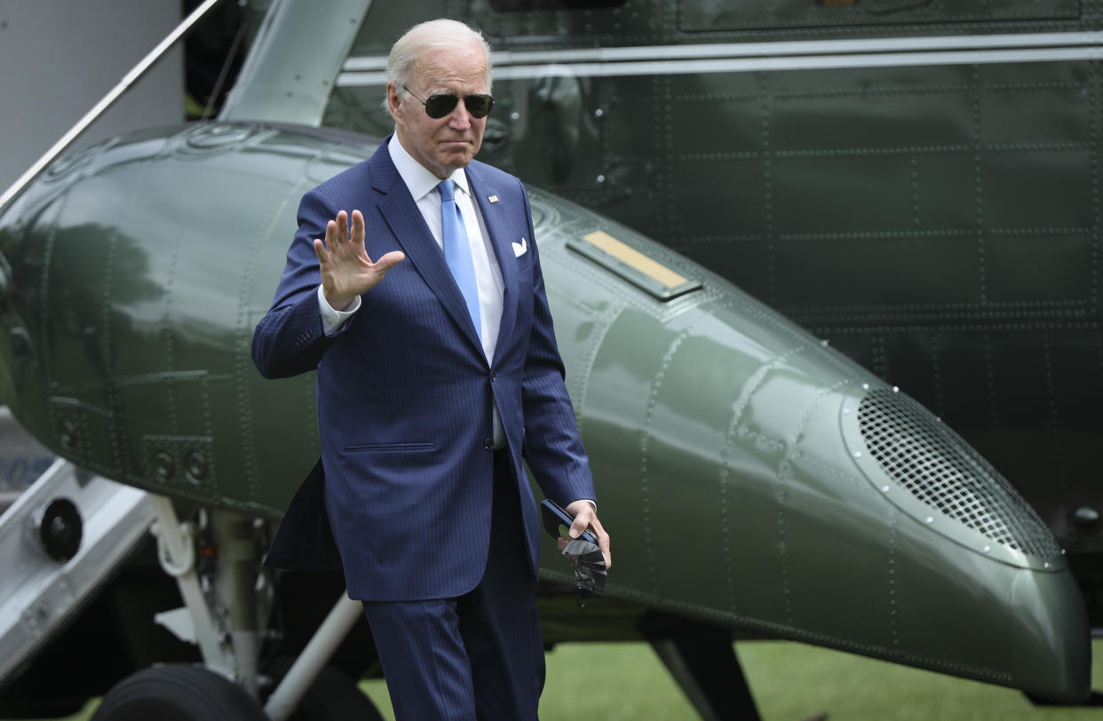 President Biden waves as he arrives at the White House.