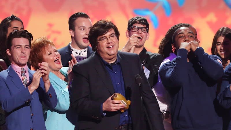 In this March 29, 2014, file photo, Dan Schneider, center, accepts the lifetime achievement award at the 27th annual Kids' Choice Awards at the Galen Center in Los Angeles.