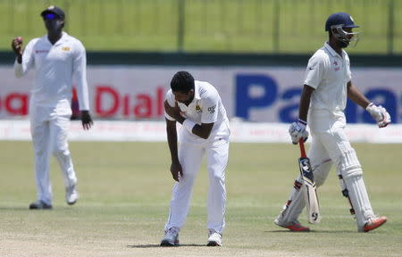 Sri Lanka's Dhammika Prasad (C) reacts due to pain during the second day of their third and final test cricket match against India in Colombo , August 29, 2015. REUTERS/Dinuka Liyanawatte