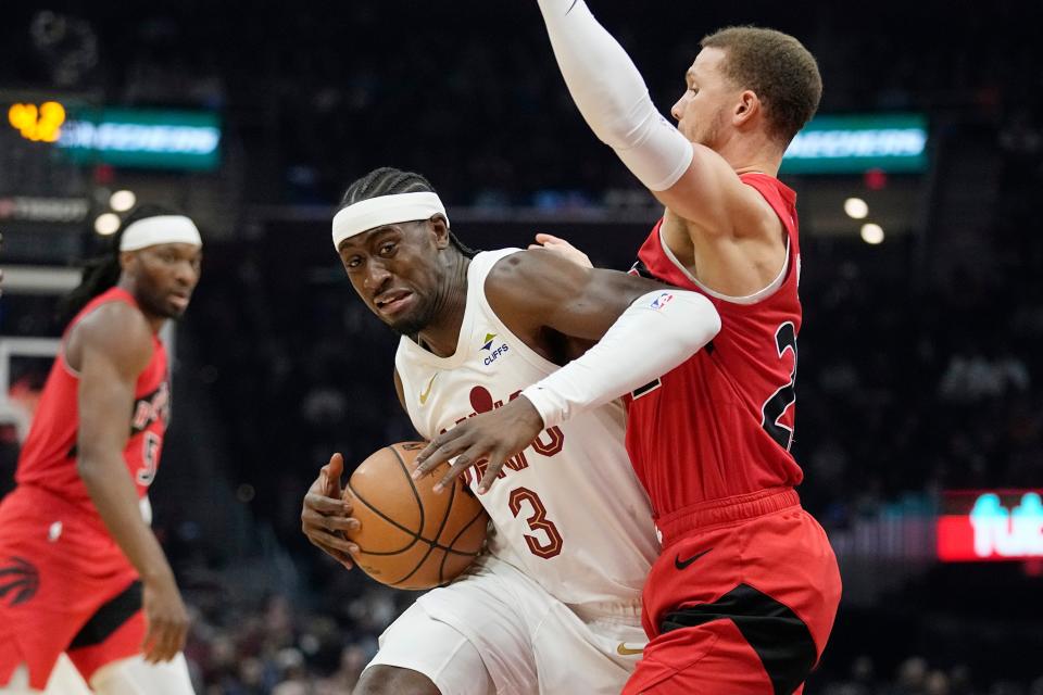 Cavaliers guard Caris LeVert drives around Toronto Raptors guard Malachi Flynn, right, in the first half, Sunday, Nov. 26, 2023, in Cleveland.