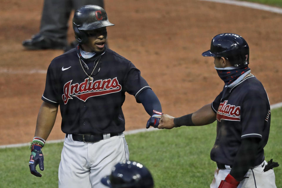 Cleveland Indians' Francisco Lindor, left, is congratulated by Cesar Hernandez after hitting a three-run home run in the fifth inning during a preseason baseball game against the Pittsburgh Pirates, Monday, July 20, 2020, in Cleveland. (AP Photo/Tony Dejak)