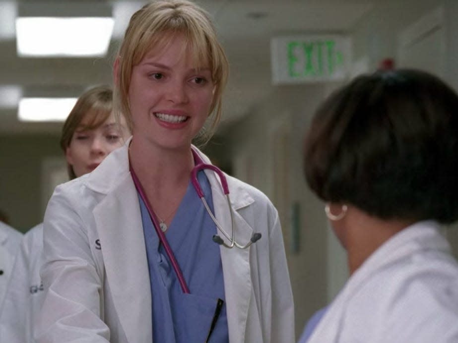 Katherine Heigl as Izzie on Greys Anatomy, shaking Baileys hand and wearing scrubs and a coat