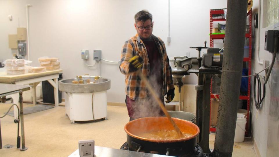 Lee’s Candies employee Isaac Duff stirs caramel in a copper kettle in the store’s backroom. Copper kettles are popular in commercial candy-making because copper transfers heat significantly faster than iron or stainless steel, spreading the heat more evenly across the surface of the pot.